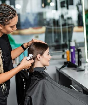 hairstylist-spraying-hair-of-female-client-hairdre-2024-11-09-03-30-16-utc (1)